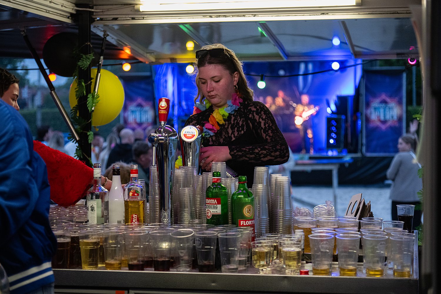 De buitenbar op Steenwijker Beach: getapte bekers op de toog, gekleurde lampjes en een band op het podium.