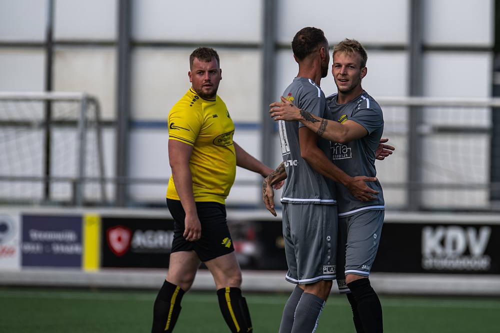 Twee spelers schouder aan schouder in de strijd om de bal.