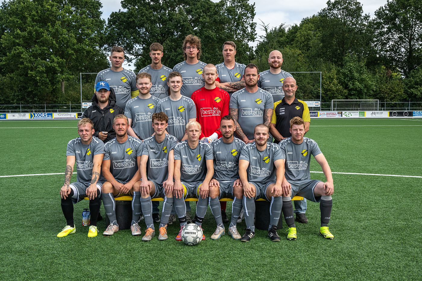 Teamfoto van Zaterdag 2 van vv Steenwijker Boys op het kunstgras: zestien spelers en twee leiders in het grijze uitshirt met Bestaria Steenwijk op de borst.